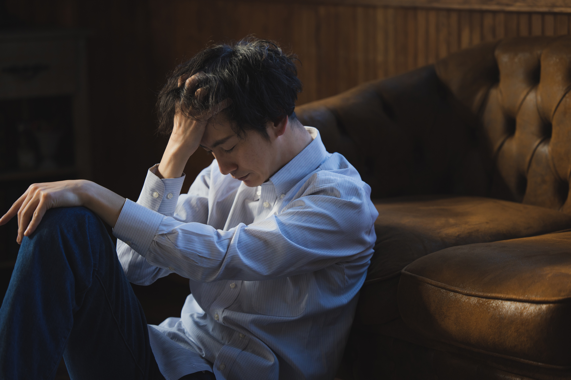 職業訓練受講給付金を受給するデメリットを感じてうなだれる男性