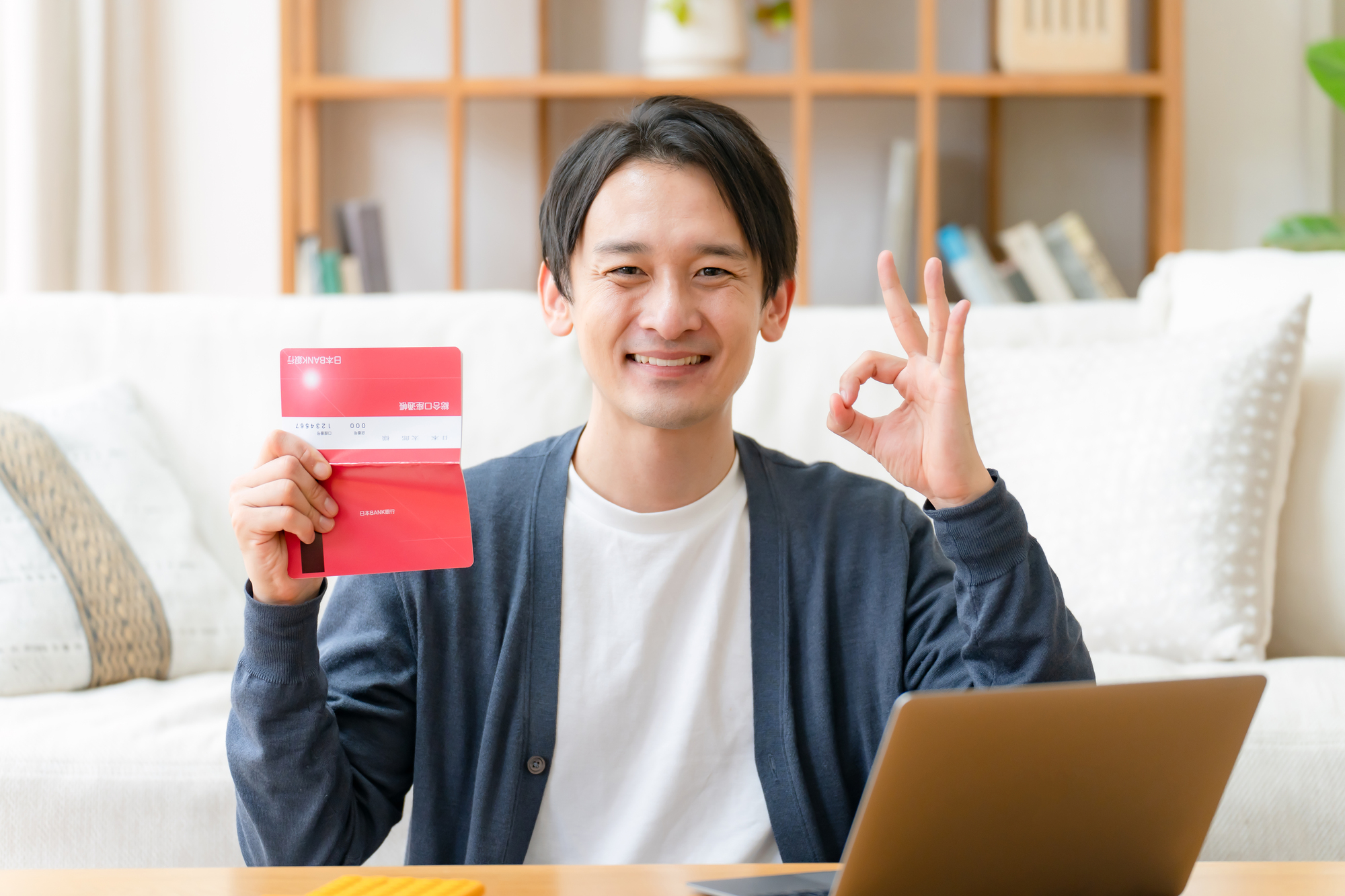 通帳を笑顔で持っている男性